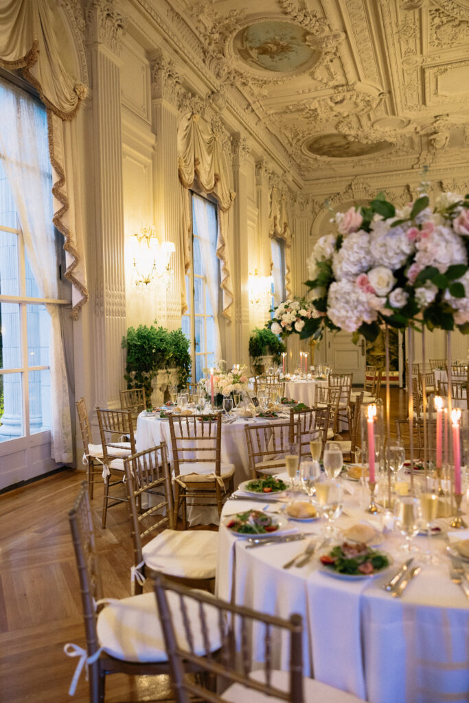 Candlelit reception tables with soft florals and gold chairs inside an ornate ballroom, showing the refined details an editorial wedding photographer in Vermont can preserve.