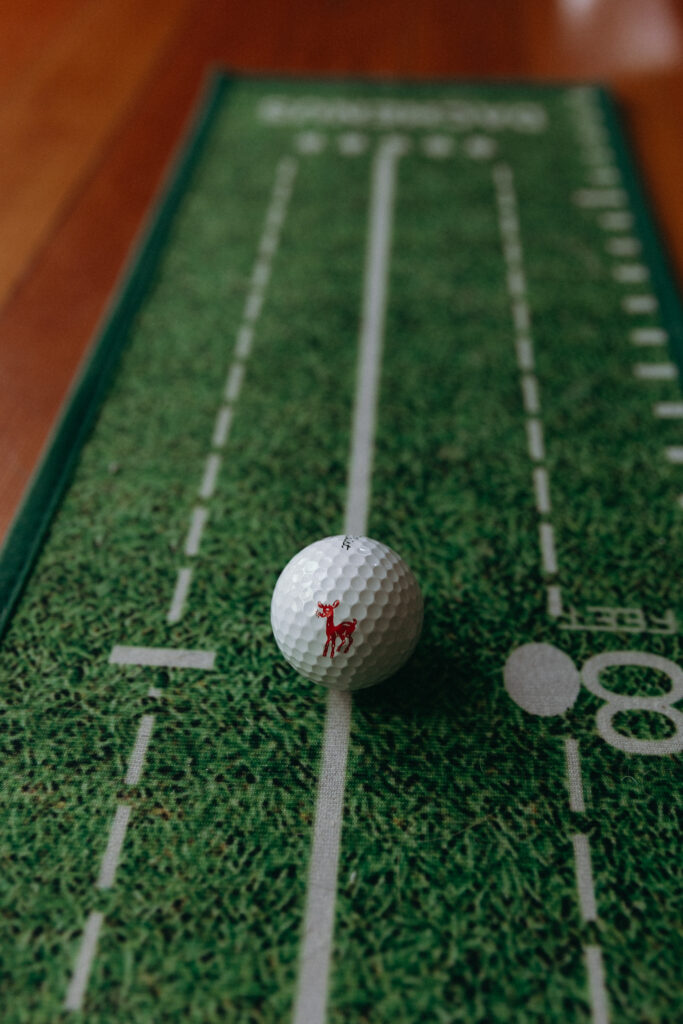 White golf ball on a miniature football field, a playful personal detail at a Basin Harbor wedding